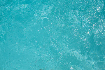 Ripple details blue water swimming pool with sun reflection and bubbles