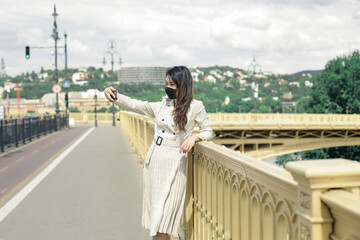 Asian girl with mask is walking on the bridge