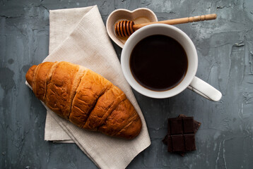 Breakfast: coffee, croissant, honey and chocolate. Top view.