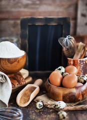 Baking ingredients and blackboard on background, wooden rustic style