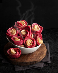 Dumplings in the shape of a rose flower on a black background. Chinese dumplings.