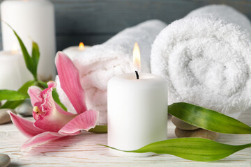 Composition with candles, towels, stones and orchid on wooden table. Zen concept