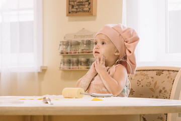 Little girl cooks at home in the kitchen