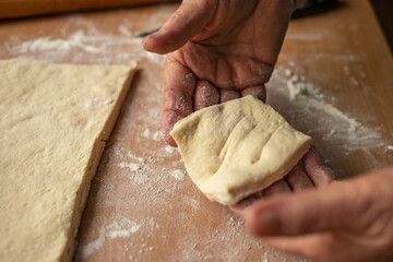 Grandmother's hands are preparing homemade dough for baking. Side view.