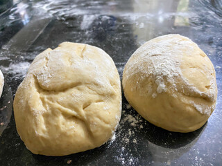 Homemade rearing yeast bread dough and rolling pin on kitchen counter