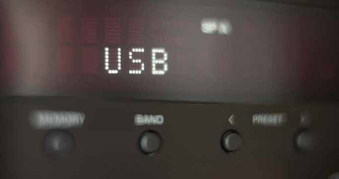 Audio device playing music. Close up view of audio player display in process. Many symbols on the screen. Moving reflection on it`s surface