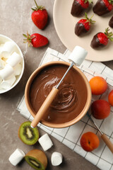 Composition with ingredients for chocolate fondue on gray table. Cooking fondue