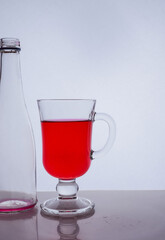 red liquid into a glass on a white background light effect