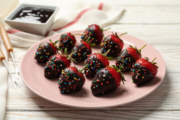Chocolate fondue. Strawberry in chocolate on white wooden background