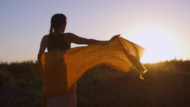 Young boho woman performing dance at beach summer music festival
