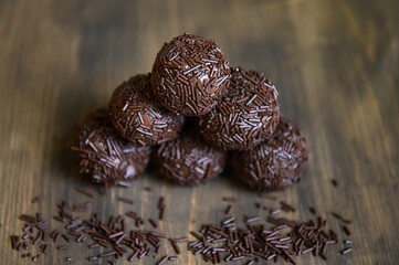 Brazilian chocolate truffle bonbon brigadeiro on wooden table. Selective focus.
