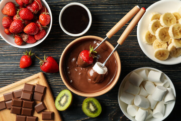 Composition with ingredients for chocolate fondue on wooden background. Cooking fondue