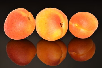 Ripe sweet, organic apricots, close-up, on a black background.