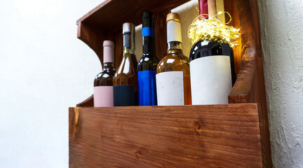 Set of bottles and glass of elite red wine on wooden shelf at home. Concept of lifestyle relax, copy space.