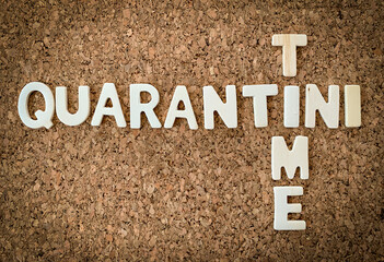 Wood letters on a cork background. "Quarantini time." Funny joke, quote or meme for covid-19 or coronvirus pandemic. 