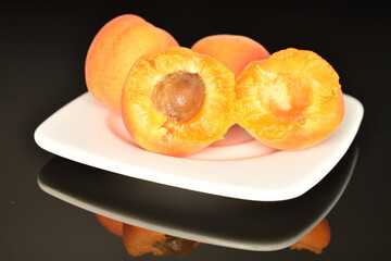 Naklejka na ściany i meble Ripe sweet, organic apricots, close-up, on a black background.