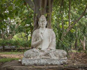 Fototapeta na wymiar weathered stone buddha image in a forest