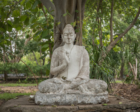 weathered stone buddha image in a forest