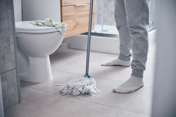 Male in cotton socks holding a mop