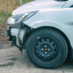 A white car without a front bumper. Side view