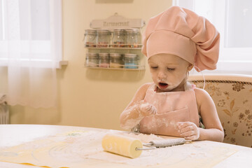 Little girl cooks at home in the kitchen