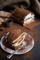 Tiramisu cake on a dark slate,stone or metal background. Selective focus