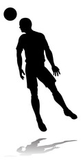 A soccer or football player in silhouette