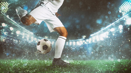 Close up of a soccer scene at night match with player in a white uniform kicking the ball with power - obrazy, fototapety, plakaty