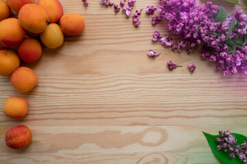 Natural background: apricots and lilac flowers on a wooden table