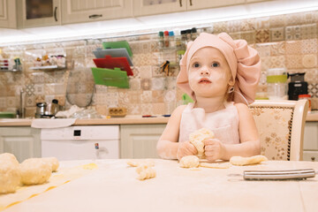 Little girl cooks at home in the kitchen