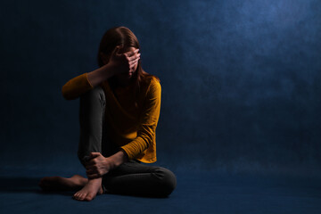 Teen girl sitting hugging his hands. Adolescent psychological and social problems.