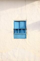 Blue simple, rural, and beautiful windows against a white rustic wall