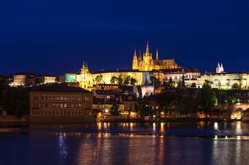 View of Prague old town, historical center with Prague Castle, St. Vitus Cathedral in Hradcany district, Charles Bridge Karluv Most, Vltava river, night twilight evening view, Bohemia, Czech Republic