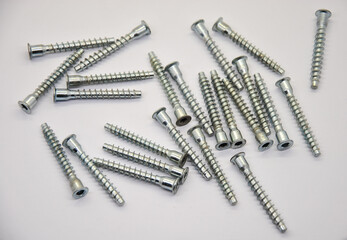 pile of metal screws on a white background