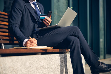 Man in official clothes working alone online outside