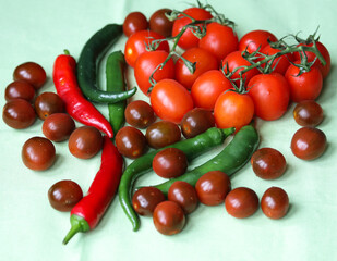 tomatoes and chili peppers  on a light background close up
