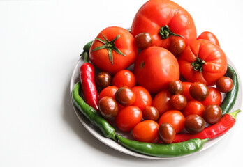 tomatoes and chili peppers  on a light background close up