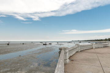 beach of Bangsaen during low tide against a blue sky with white clouds