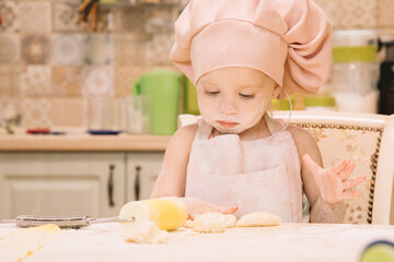Little girl cooks at home in the kitchen