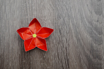 red origami paper flower on wooden