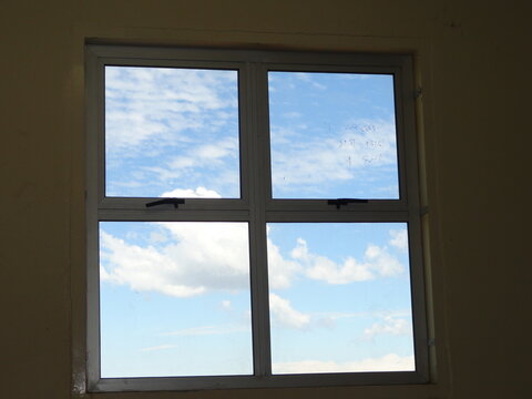 A classic window shape looking like a logo with clouds outside