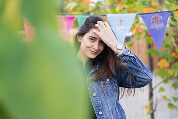 Beautiful woman with brunette hair in jeans clothes. Fashion mode showing ring and closed face by...