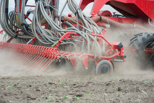 Tedder rake work in field with dust