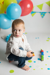 surprised child on his birthday. birthday photo zone with flags and balloons	
