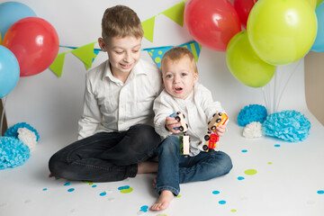 The brothers play with the train. the boy's birthday . decorations balloons and flags