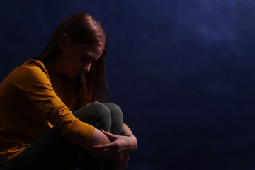 Teen girl sitting hugging his hands. Adolescent psychological and social problems.