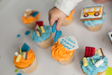 the kid chooses a cupcake. cupcakes with cream for a child's birthday. two years old child