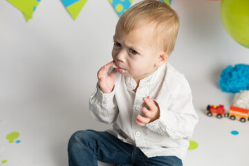 Birthday party. little boy eating his holiday cupcakes