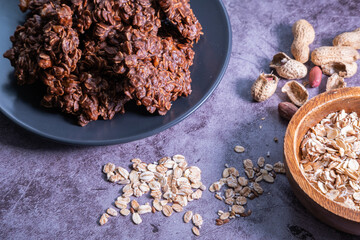 Oatmeal cookies with peanut butter, chocolate powder and coconut oil on a grey plate  on concrete background. Healthy and homemade snack. Close up view.