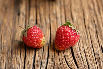  Colorful strawberries on the background of an old wooden table.